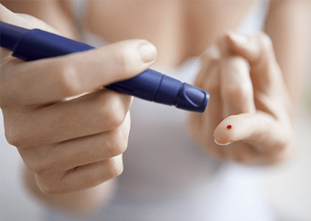 Frau, die Diabetes-Test am Zeigefinger durchführt