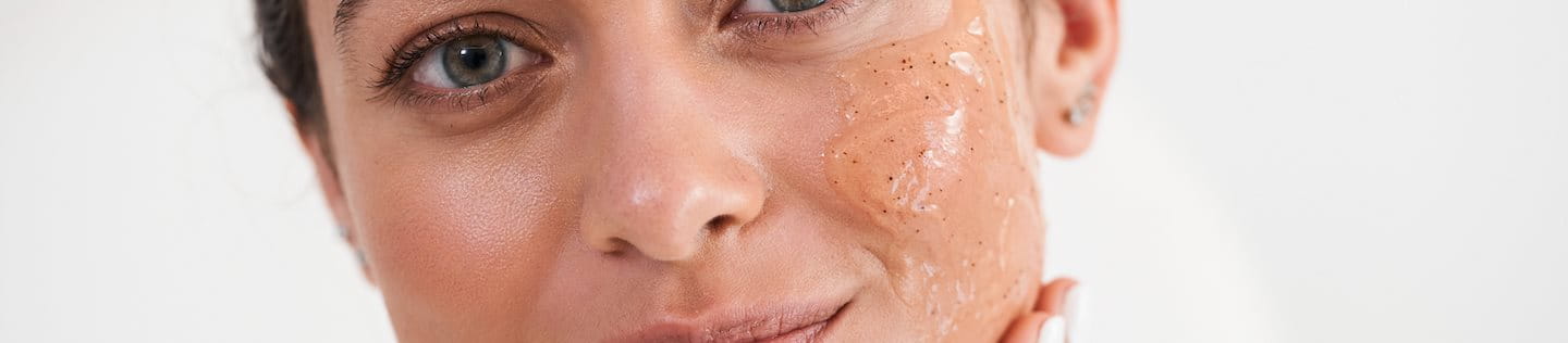 Frau trägt Glycolsäure-Peeling im Gesicht auf