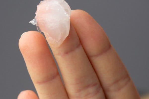 Eine Frau, die Slugging anwenden möchte und an ihrem Finger eine okklusive Salbe hat 