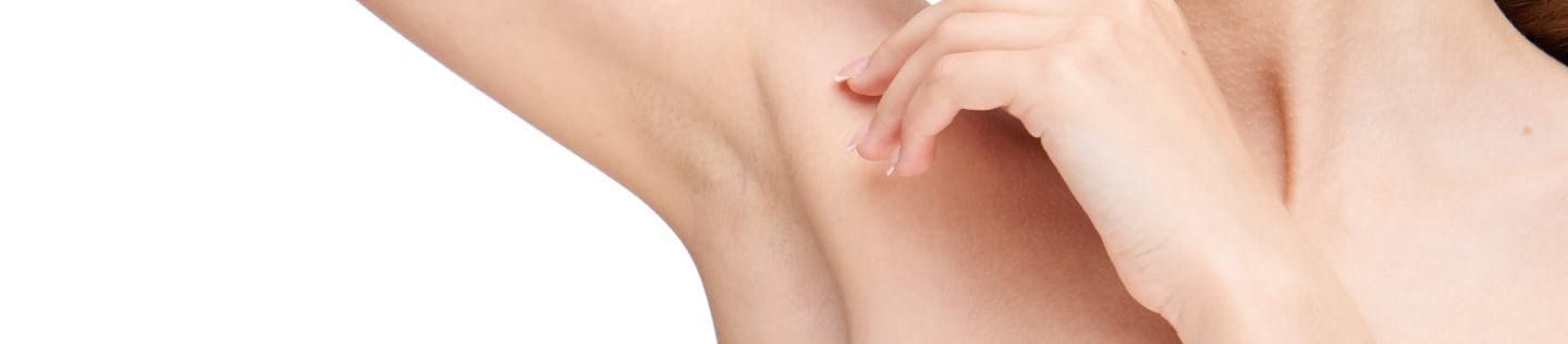 Junge frau schaut auf ihre rechte Achsel, weil sie unter juckenden Achseln leidet.