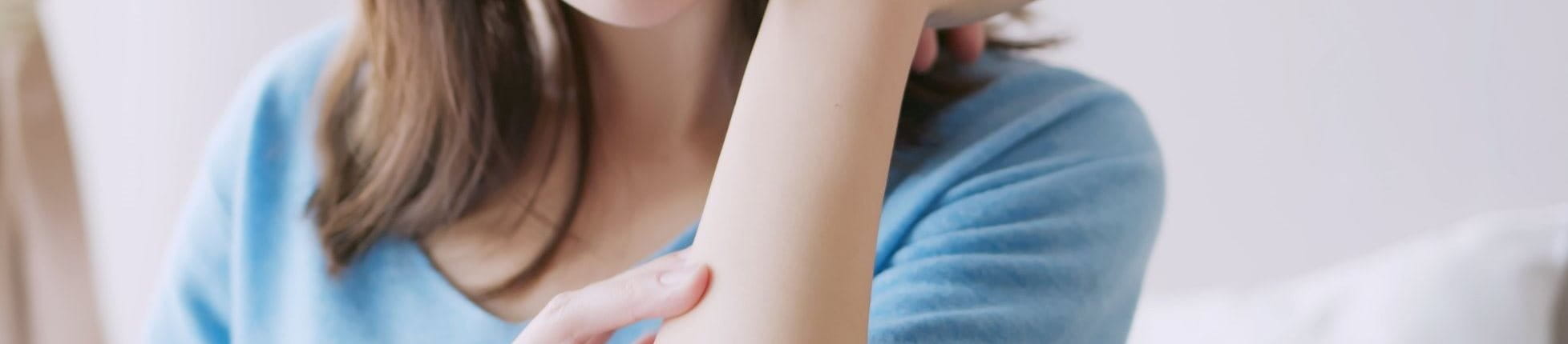 Frau untersucht ihren Arm auf Ekzeme