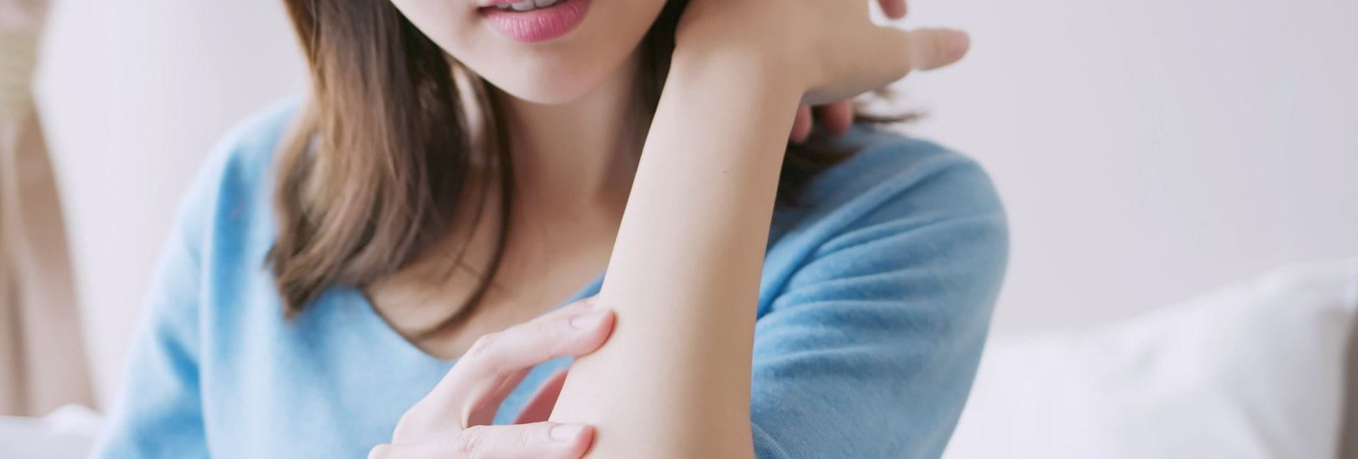 Frau untersucht ihren Arm auf Ekzeme