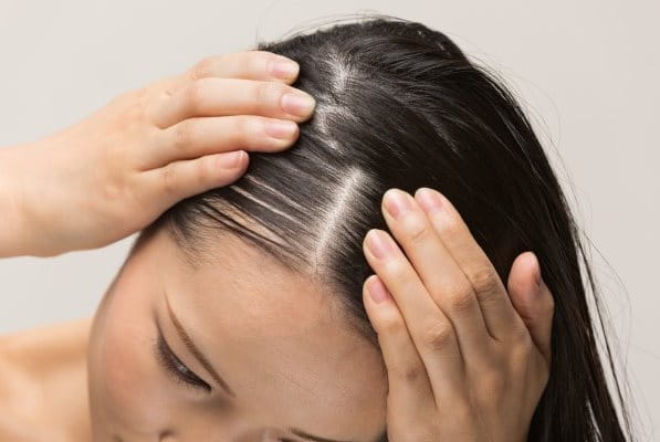Eine Frau massiert die Kopfhaut