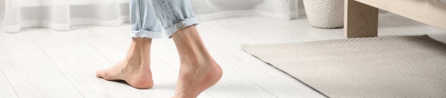 Nackte Füße auf dem Parkettboden