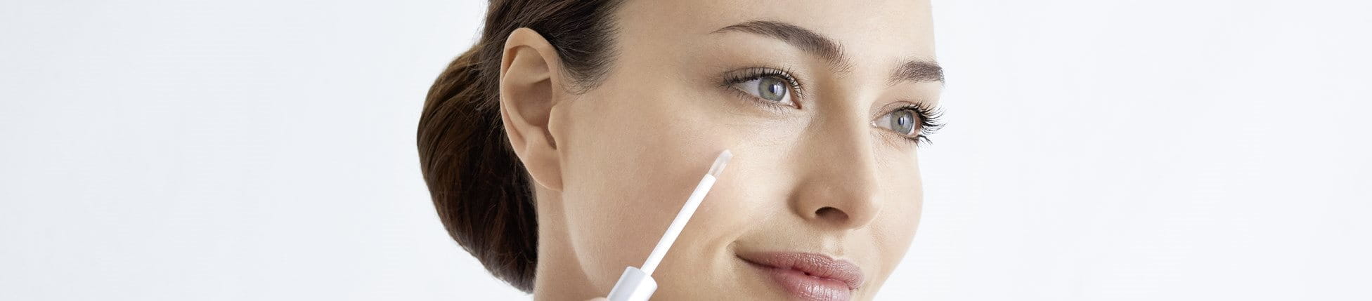 Frau trägt Thiamidol gegen Pigmentflecken im Gesicht auf