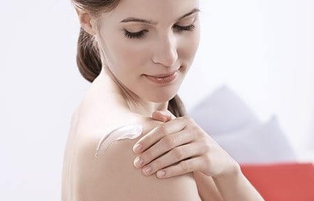 Mujer aplicándose crema para piel sensible