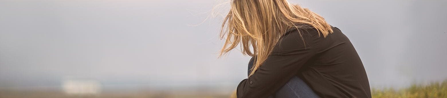 Sad woman sitting on a hill