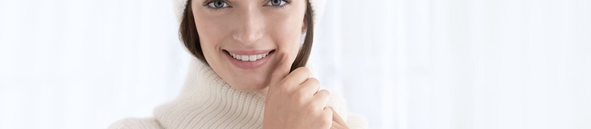 Woman wearing a winter hat and turtle neck smiling