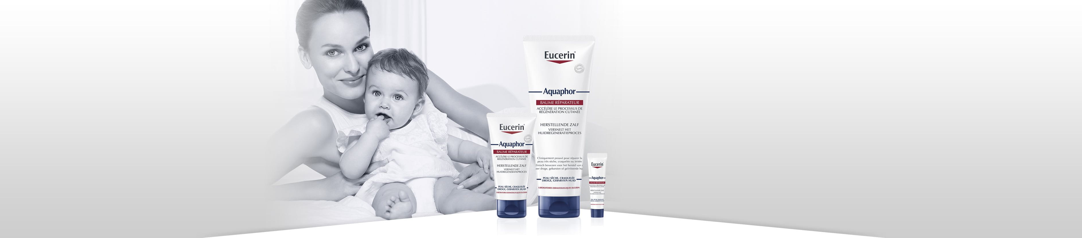 The product range Aquaphor with a mother holding a baby in the back