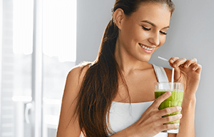 žena pije zeleni smoothie