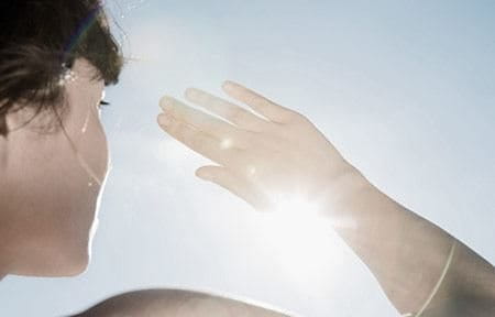 Woman blocking sun with hand