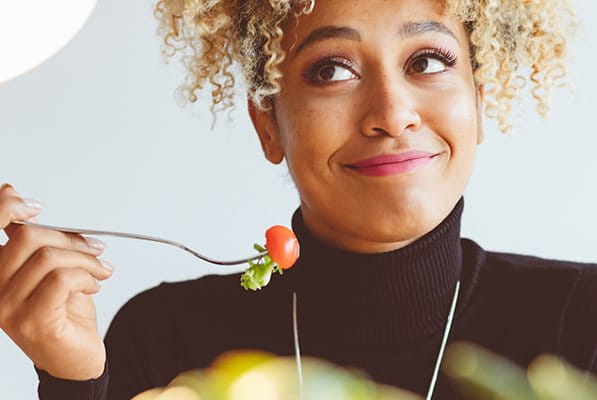 Woman eating healthy food to reduce development of blemishes