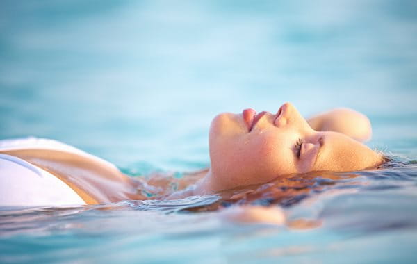 Frau lässt sich auf dem Wasser treiben