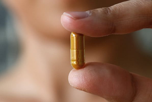 A pill being held up to the cameras focus
