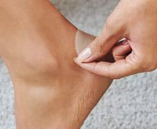 person applying blister plaster to heel