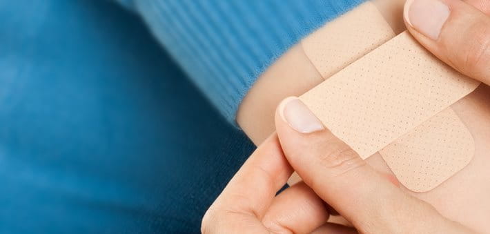 Hand putting adhesive bandage or plaster. band-aid on a cut