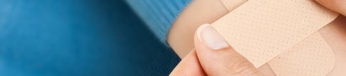 Person applying platers on an arm - banner - Elastoplast