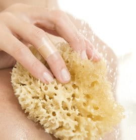 Close up of hand washing body with sponge