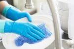 A person is wearing rubber gloves during washing dishes