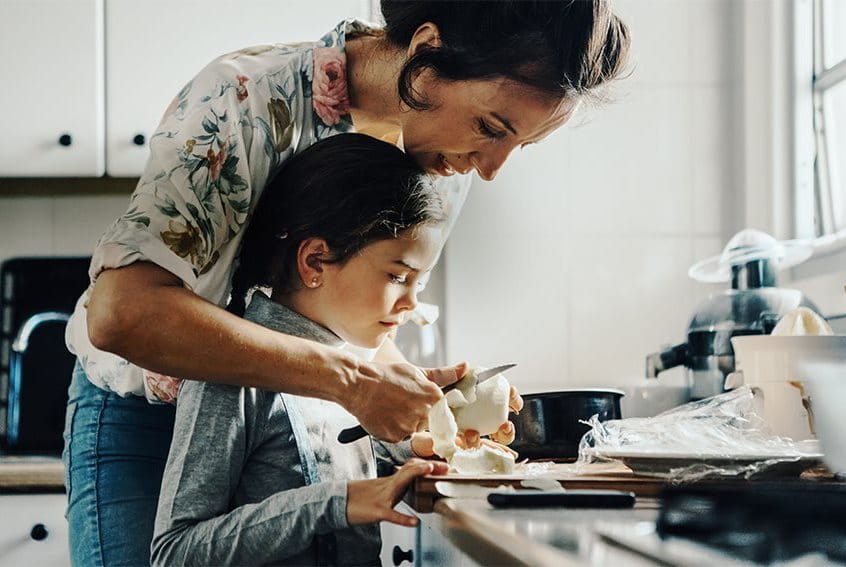 Mother and daughter in kitchen preparing fruit