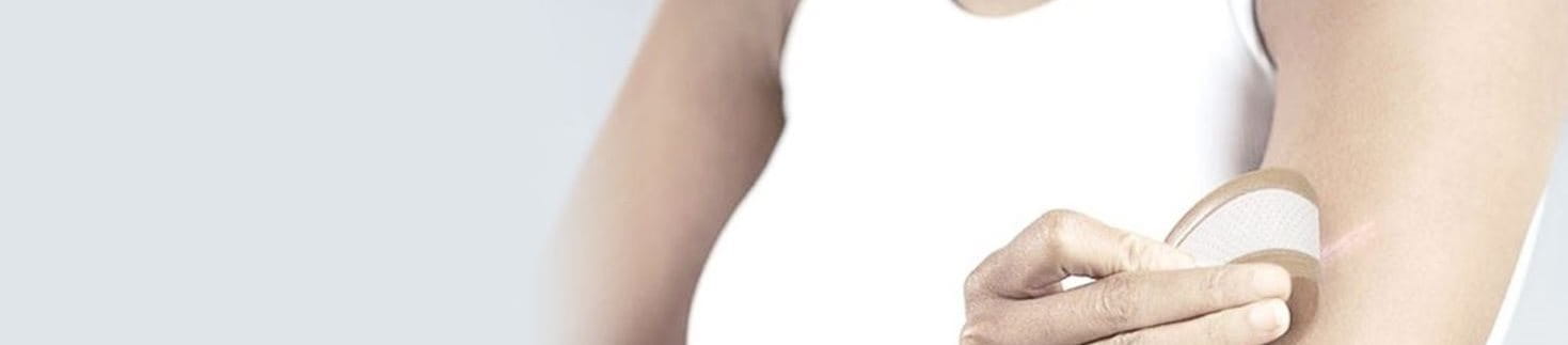 Vrouw plakt pleister op litteken op haar arm