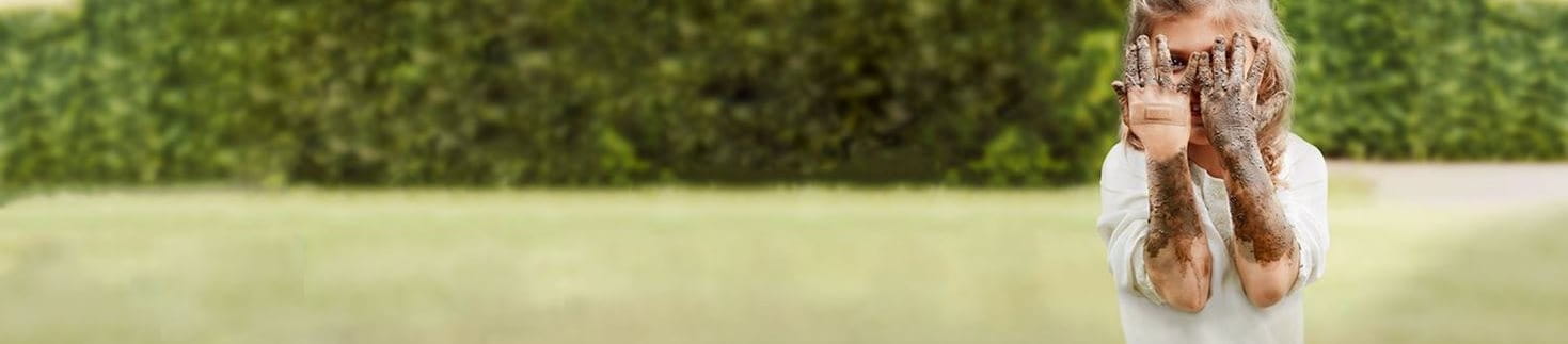 Kind hat schmutzige Arme und ein Pflaster an der Hand