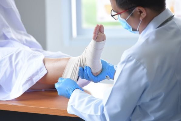 Arzt behandelt eine chronische Wunde am Fuß