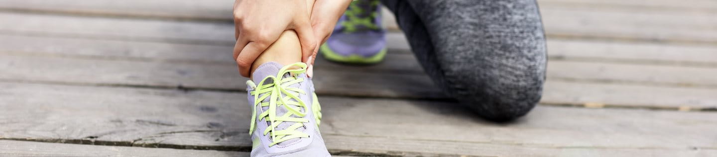 Junge Frau hält sich das schmerzende Fußgelenk