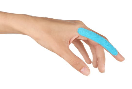Linker Zeigefinger einer Frau mit blauem Tape