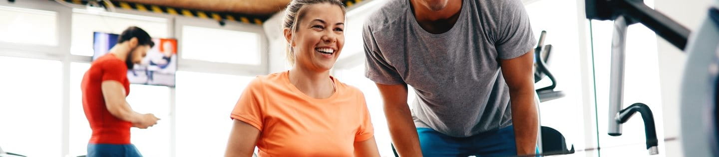 Frau trainiert an Rudermaschine im Fitnessstudio