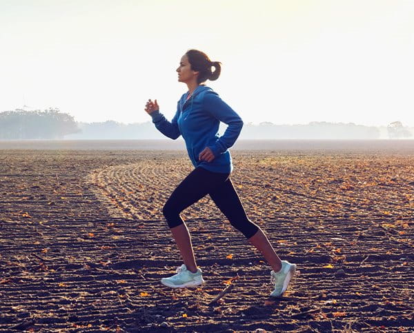 Frau joggt über ein Feld