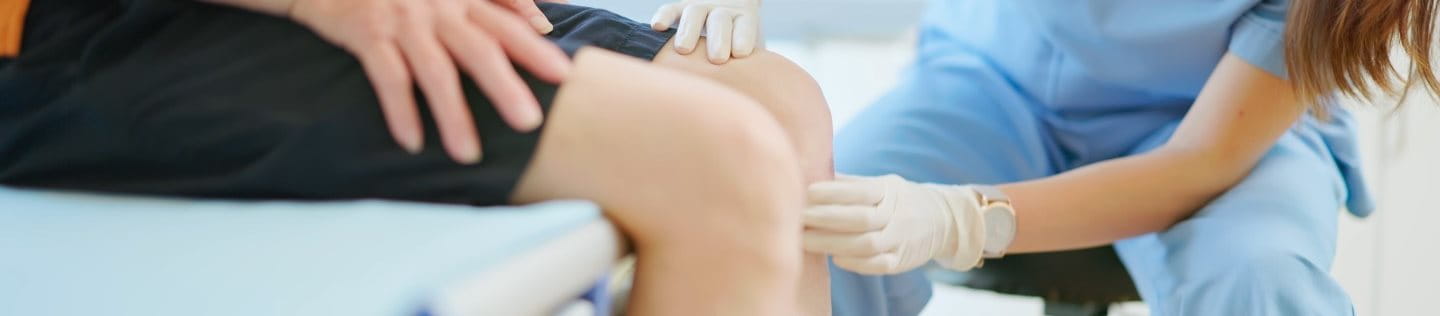 Ärztin untersucht Knie auf Meniskusschaden