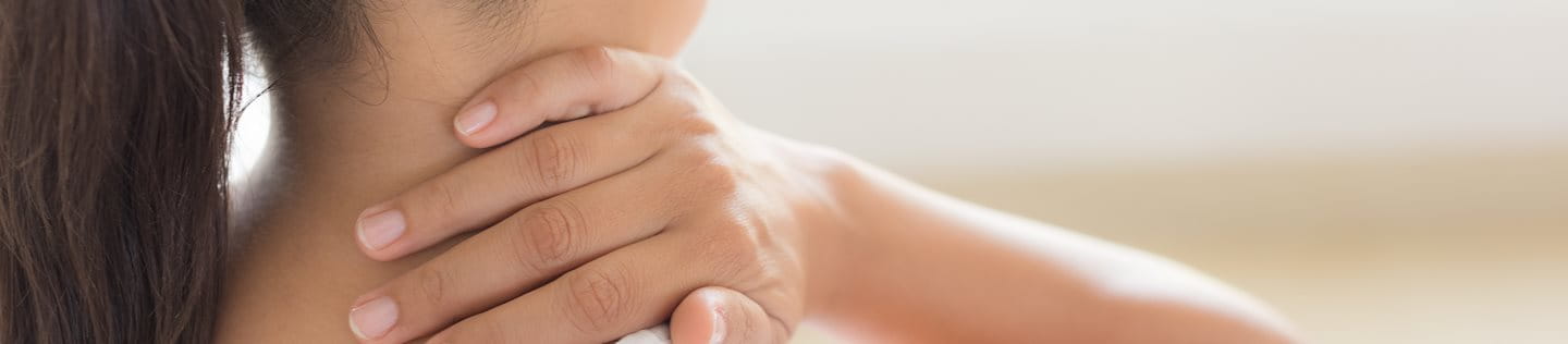 Frau legt Hand auf Nacken