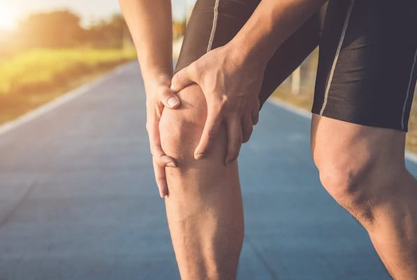 Mann hält sich Knie mit Patellaspitzensyndrom