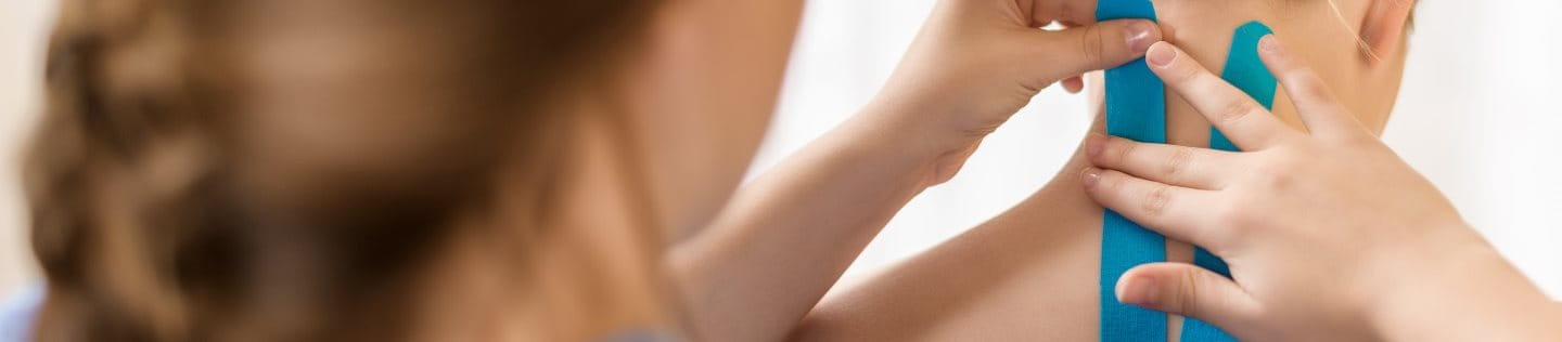 Einer Frau werden Nacken und Rücken getapt
