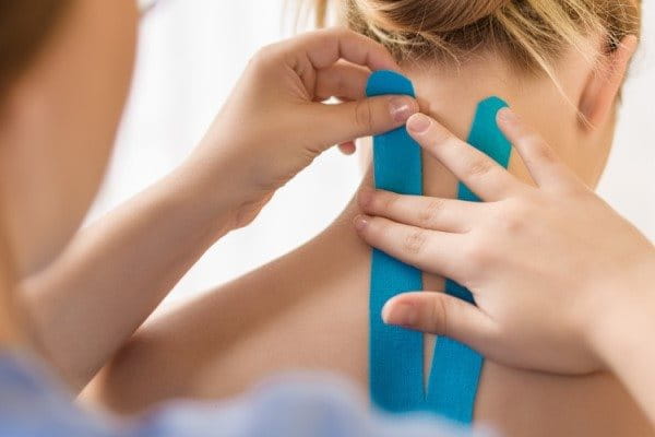 Einer Frau werden Nacken und Rücken getapt