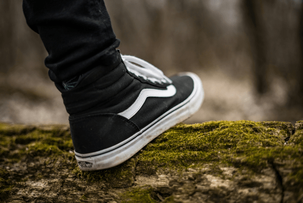 Close up shot of a persons shoe while they are walking in nature