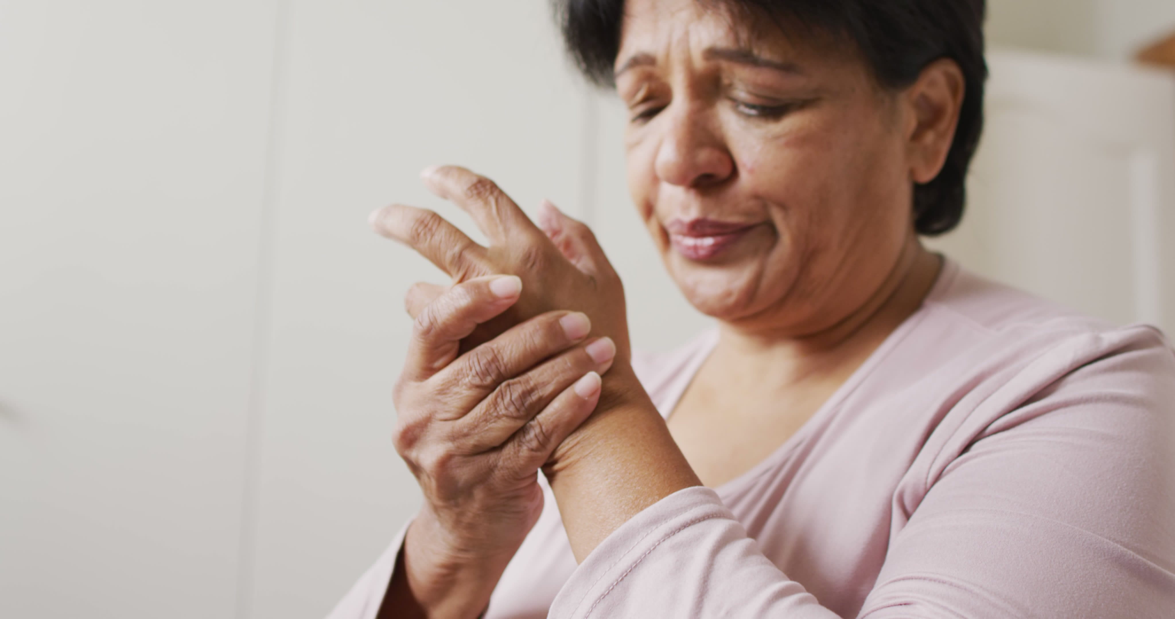 Woman holding her hand in pain