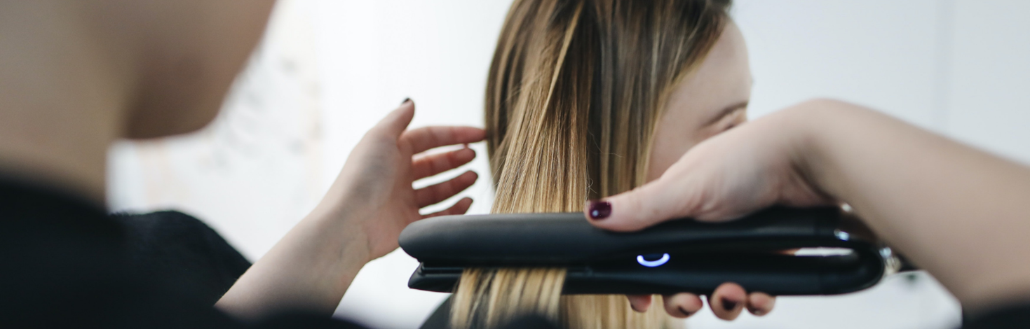 Lady using a hair straightener.