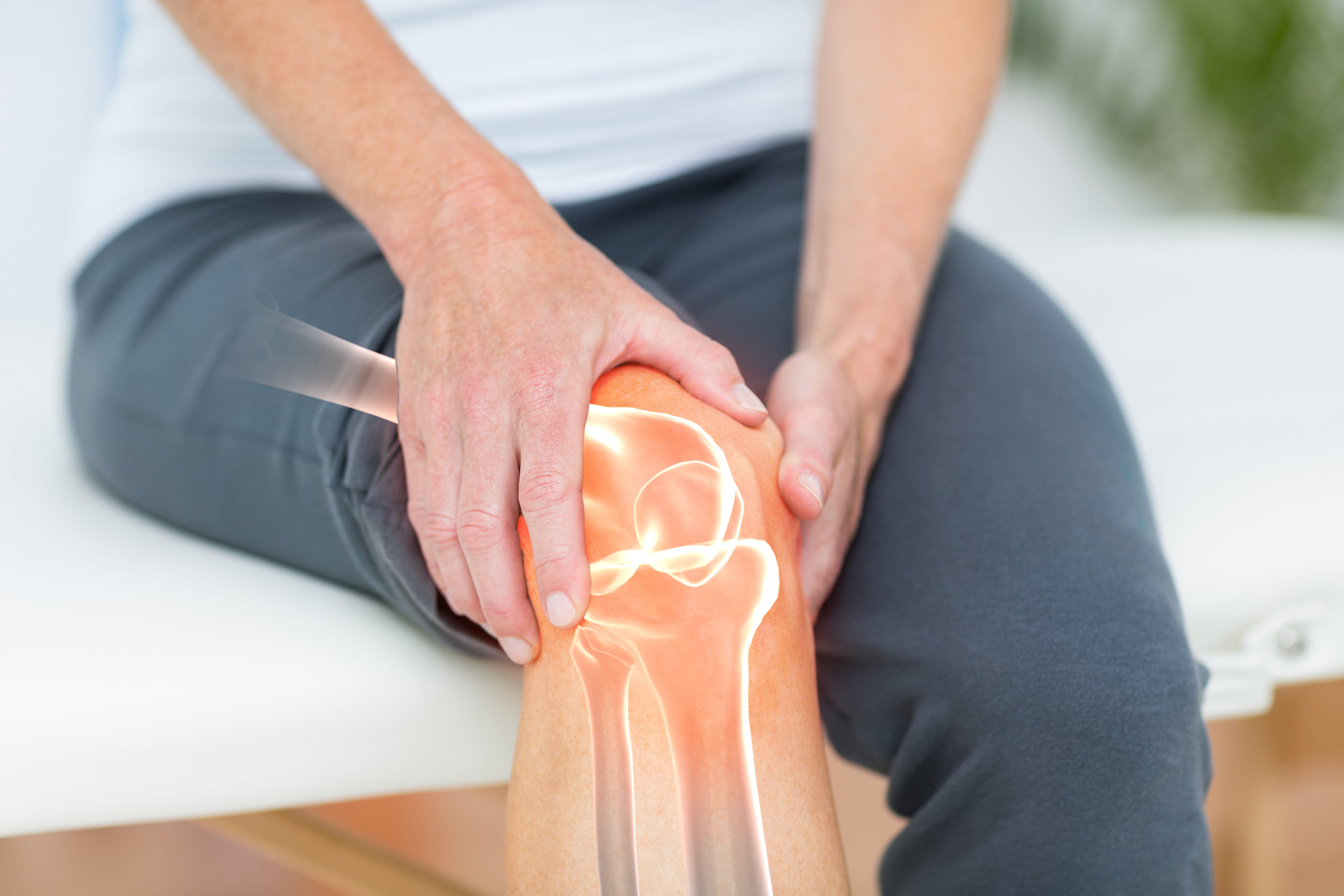Person sitting down holding knee