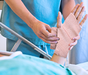 Apply the cotton crepe bandage to the strained area