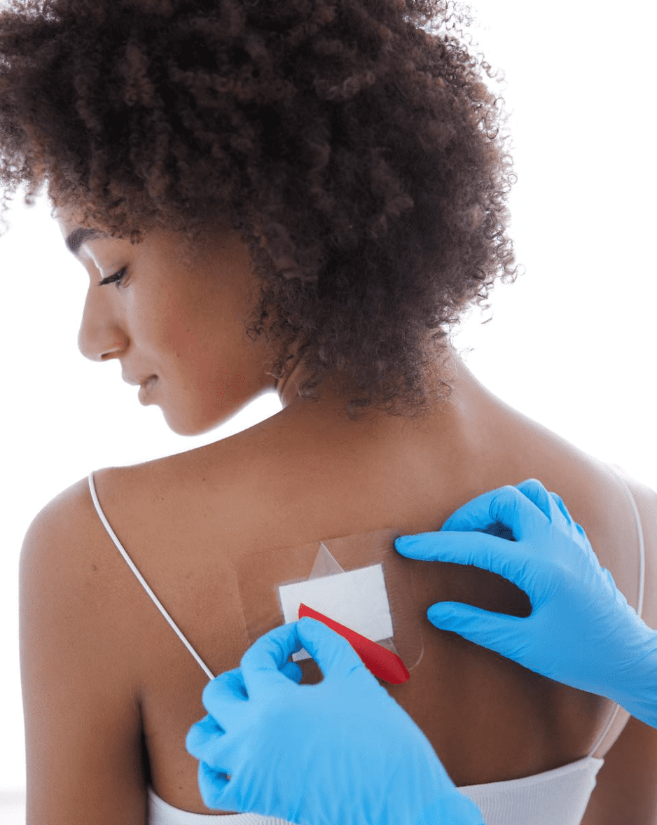 Een pleister wordt op een wond op de bovenrug geplakt