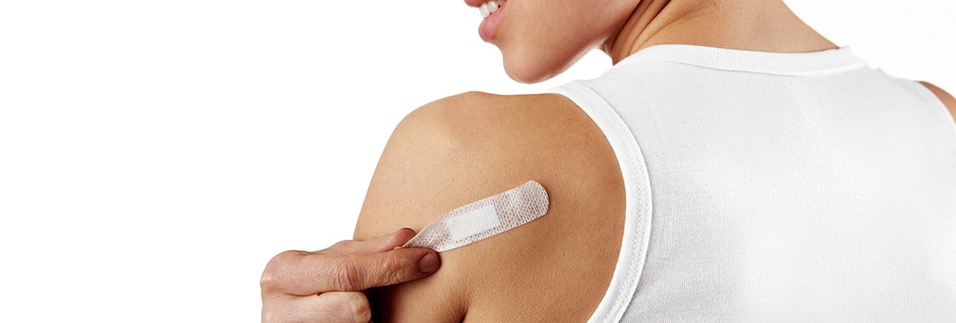 Eine junge Frau entfernt ein Pflaster