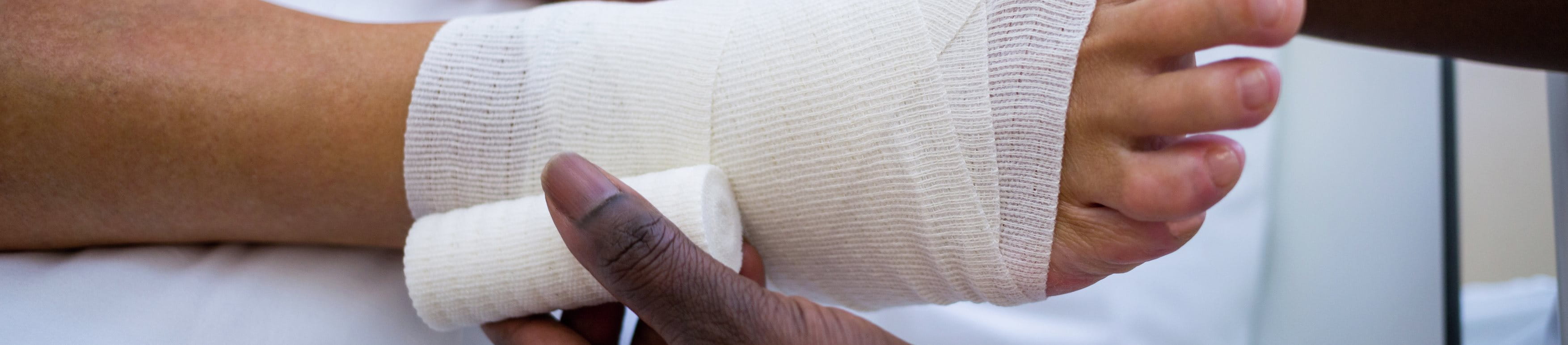 Doctor wrapping someone’s foot with a bandage