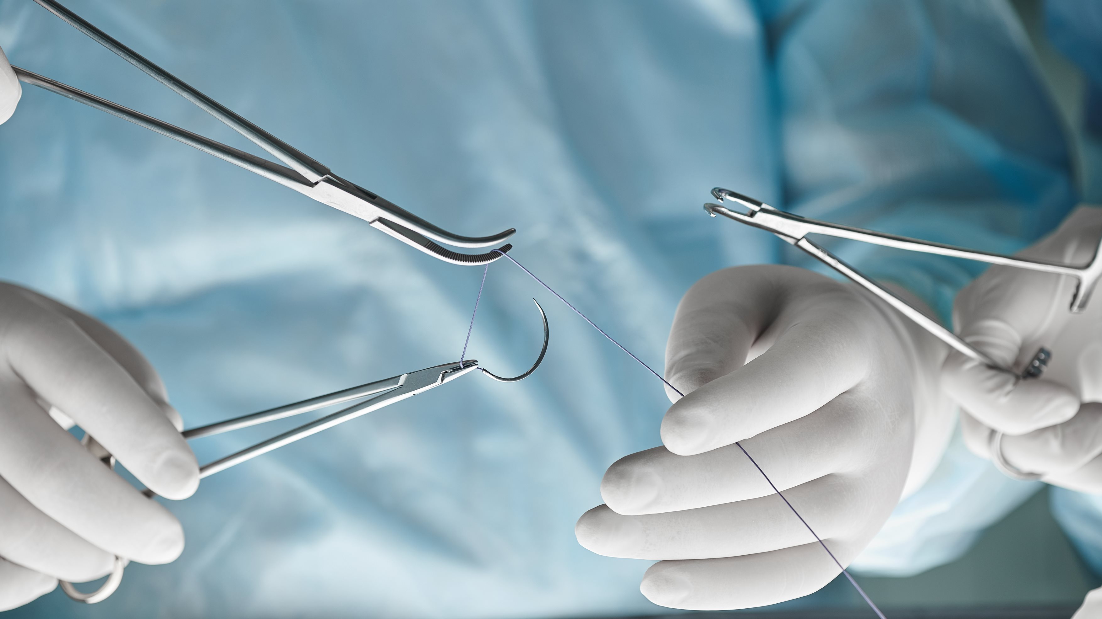Chirurgenhände mit OP Besteck